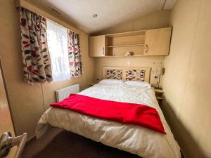 ein Schlafzimmer mit einem Bett mit einer roten Decke darauf in der Unterkunft Dog Friendly 8 Berth Caravan At Dovercourt Holiday Park In Essex Ref 44504P in Great Oakley + 17 Fotos