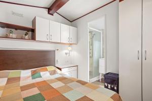 a bedroom with a bed and white cabinets at Mobilhome Puget-sur-argens in Puget-sur Argens