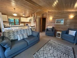 a living room with a couch and two chairs and a kitchen at Mallard Lodge - Arscott Lodges in Shrewsbury