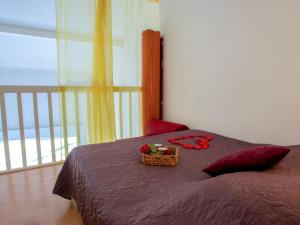 ein Schlafzimmer mit einem Bett mit einem Blumenkorb darauf in der Unterkunft Apartment L'Orée du Golf-2 by Interhome in Pornic