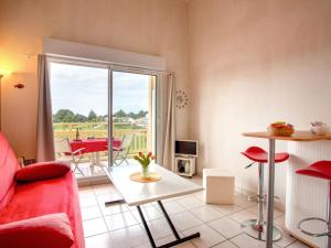 ein Wohnzimmer mit einem roten Sofa und einem Tisch in der Unterkunft Apartment L'Orée du Golf-2 by Interhome in Pornic