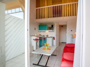 eine Küche und ein Wohnzimmer mit einem Tisch und roten Stühlen in der Unterkunft Apartment L'Orée du Golf-2 by Interhome in Pornic + 20 Fotos