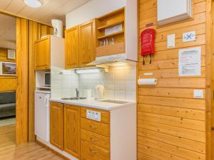 une cuisine avec des armoires en bois et un évier dans l'établissement Holiday Home Huhmari 12 by Interhome, à Polvijärvi