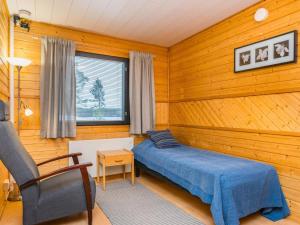 une chambre avec un lit dans une pièce aux murs en bois dans l'établissement Holiday Home Huhmari 12 by Interhome, à Polvijärvi 11 autres photos
