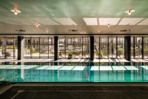 克雷尼察BELMONTE Hotel Krynica-Zdrój的建筑物内的游泳池，窗户位于其中