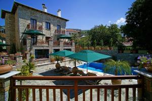ポルタリアにあるMaritsas Hotel & Suitesのパティオ(緑のパラソル、椅子付)、プールが備わります。