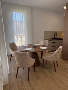 ein Esszimmer mit Tisch und Stühlen und eine Küche in der Unterkunft Apart Hotel Spa Resort Becici, Budva Апартаменты с двумя мастер-спальнями in Becici