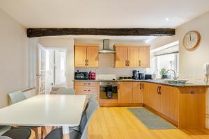 a kitchen with wooden cabinets and a table and chairs at Hummingbird House in Cockermouth