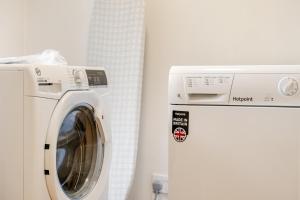 a white washing machine next to a white refrigerator at Hummingbird House in Cockermouth