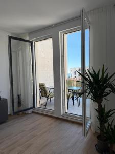 ein Wohnzimmer mit Glasschiebetüren und einem Tisch in der Unterkunft Apart Hotel Spa Resort Becici, Budva Апартаменты с двумя мастер-спальнями in Becici + 24 Fotos