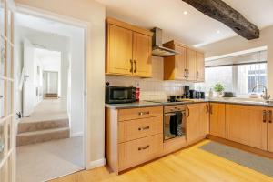 a kitchen with wooden cabinets and a sink and a microwave at Hummingbird House in Cockermouth +14 photos