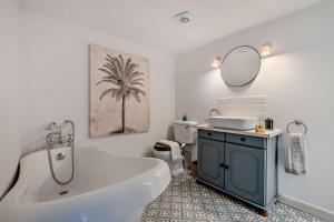 a bathroom with a tub and a sink and a mirror at Saltwater Stunning Holiday Terraced House Milford on Sea Lymington Sleeps 6 in Milford on Sea