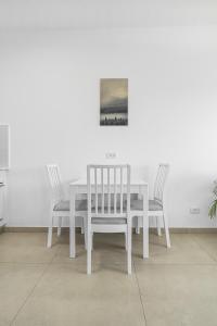 埃拉特Luxury Suite Apartment With Sea View #55 By Hashdera Eilat的一张带两把椅子的白色餐桌和一幅画