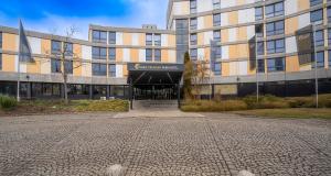 an external view of a building with a cobblestone driveway at PLAZA Premium Parkhotel Neu-Ulm in Ulm +53 photos