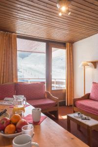 - un salon avec une table et une corbeille de fruits dans l'établissement Abrineige Le Schuss Val Thorens, à Val Thorens