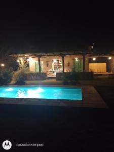 a swimming pool in front of a house at night at El rancho de Ana in Colonia Las Rosas