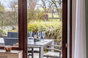 una mesa con copas y botellas de vino en el patio en Fewo Strandliebe, en Gaienhofen 4 fotos más