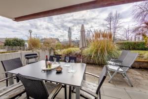 Un patio con una mesa y sillas y una sombrilla. en Fewo Strandliebe, en Gaienhofen