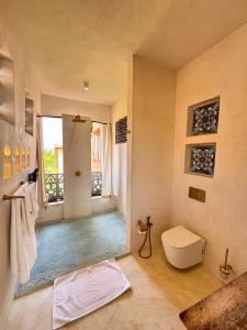a bathroom with a shower and a toilet in it at Al Mahali Villas Diani Beach in Diani Beach