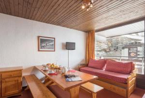 un salon avec un canapé et une table dans l'établissement Abrineige Le Schuss Val Thorens, à Val Thorens