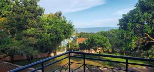 un balcone con vista sugli alberi e sull'erba di Ngaali Nest a Entebbe