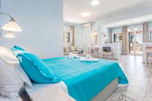 a bedroom with a blue bed and a living room at Stafylos Suites & Boutique hotel in Stafylos