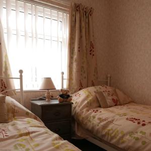 a bedroom with two twin beds and a window at 35 Siesta Mar in Mundesley