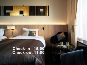 a hotel room with a bed and a chair and a table at Millennium Mitsui Garden Hotel Tokyo - Ginza in Tokyo