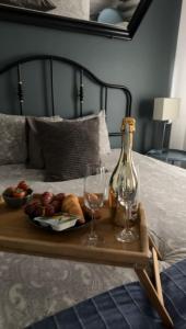 a tray of fruit and wine glasses on a bed at Apartamenty Młyńska15 self check-in 24h in Katowice