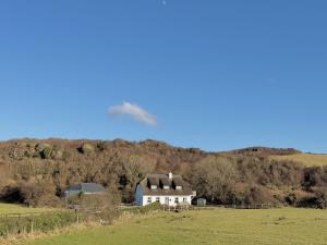 a white farm house in the middle of a field at Stargazers Cottage in Doolin