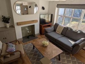 a living room with a couch and a table at Plumtree Cottage in Farnsfield