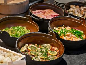a bunch of pots filled with different types of food at Millennium Mitsui Garden Hotel Tokyo - Ginza in Tokyo