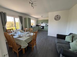 a kitchen and dining room with a table and chairs at Christinas Cottage Downpatrick in Raholp
