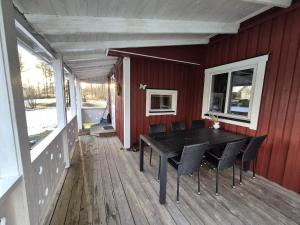 a porch with a table and chairs on a deck at 'Bij de buren' in Norra Skoga