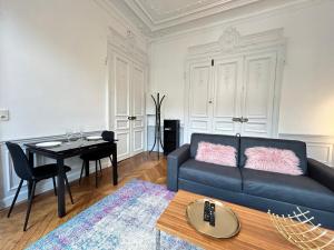 a living room with a couch and a table at Libergier superbe T2 à côté de la cathédrale in Reims +19 photos