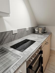 a kitchen with a stove and a counter top at Deluxe Urban Retreat Studio Apartment in London