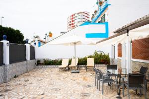een terras met een tafel, stoelen en een parasol bij A&N Refugio del Mar in Torre del Mar