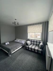 a bedroom with two beds and a couch in it at Аpartments Central Town Містечко Центральне з власним паркінгом та документами на проживання in Ivano-Frankivsʼk
