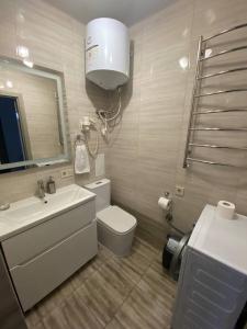 a bathroom with a toilet and a sink and a mirror at Аpartments Central Town Містечко Центральне з власним паркінгом та документами на проживання in Ivano-Frankivsʼk