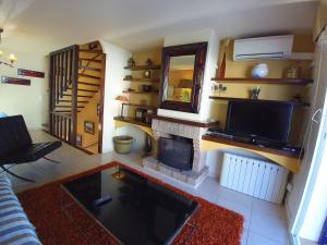 a living room with a fireplace and a television at Port Empuries in Empuriabrava