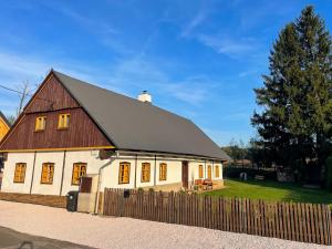 切尔尼杜尔Chalupa Rozálka的带有黑色屋顶和围栏的白色谷仓