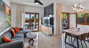 a living room with a couch and a tv and a table at Villa HG08 Pyrinas in Kouklia