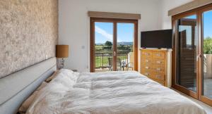 a bedroom with a bed and a television and a balcony at Villa HG08 Pyrinas in Kouklia +21 photos