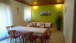 ein Esszimmer mit Tischen und Stühlen und einer grünen Wand in der Unterkunft Gästehaus Steinmetz in Sankt Martin an der Raab