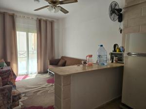 a kitchen with a counter and a living room at شالية مكيف غرفتين,ولفنج ,وحمام كامل, وتراس يرى البحر قرية بلوا لاجون 2 ليله اقل حجز عائلات فقط من فضلك in Ras Sedr