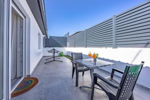 a patio with a table and chairs on a balcony at Barbariga Beach Paradise 1 in Peroj