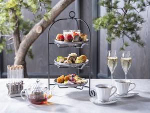 a table with two plates of food and glasses of wine at Millennium Mitsui Garden Hotel Tokyo - Ginza in Tokyo