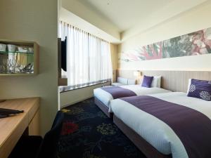 a hotel room with two beds and a window at Millennium Mitsui Garden Hotel Tokyo - Ginza in Tokyo