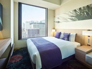 a hotel room with a large bed and a window at Millennium Mitsui Garden Hotel Tokyo - Ginza in Tokyo