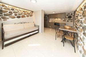 a living room and kitchen with a bench and a table at Ονειρόπετρα 2 in Mouzaki